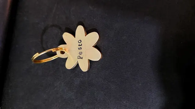 Flower-shaped brass tag with stamped name
