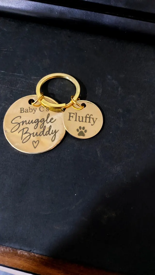 Two engraved brass pet tags on a split ring