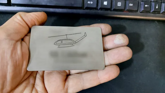 Engraved stainless steel business card held in hand